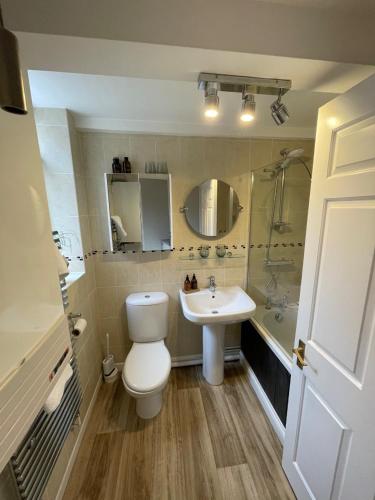 a bathroom with a white toilet and a sink at The Snug in Great Malvern