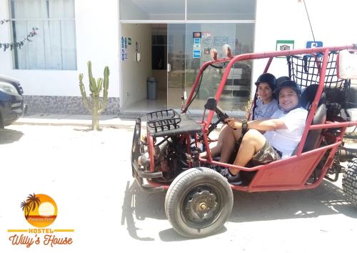 two women are sitting in a golf cart at Hostel Willys House in Paracas