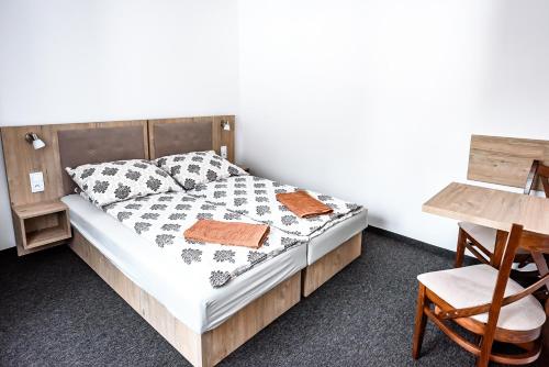a bedroom with a bed and a table and a chair at Willa Dorota in Krynica Zdrój
