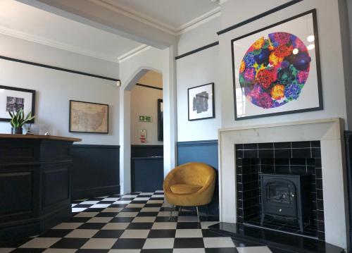 a living room with a fireplace and a chair at The Coach House Suffolk in Lowestoft