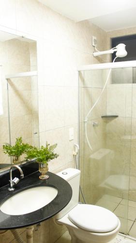 a bathroom with a toilet and a sink and a shower at Atlântico Flat Natal in Natal