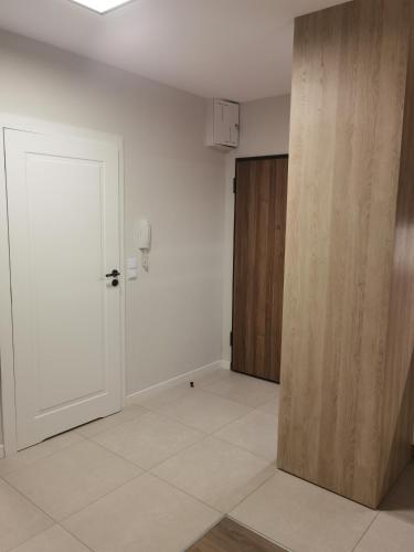 an empty room with a door and a hallway at Meduza w Bel Mare in Międzyzdroje