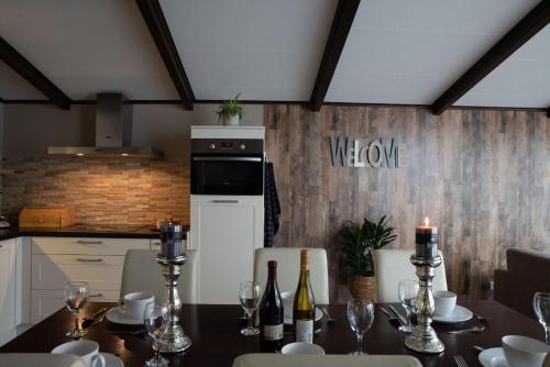 a dining room with a table with wine bottles at Welgedacht in Sint Annaland
