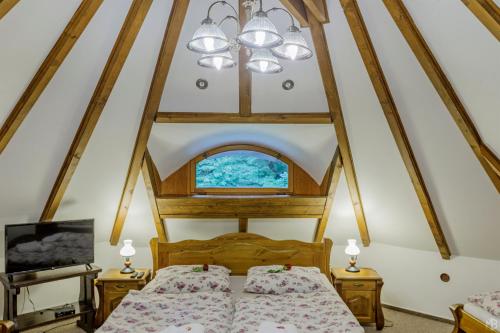 an attic bedroom with two beds and a window at Stara Plynarna in Hřensko