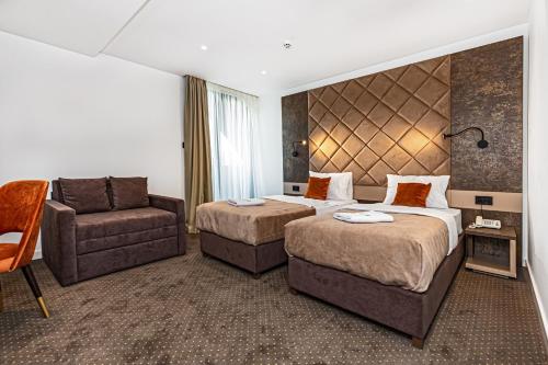 a hotel room with two beds and a chair at Hotel Ub Aqua Park in Ub