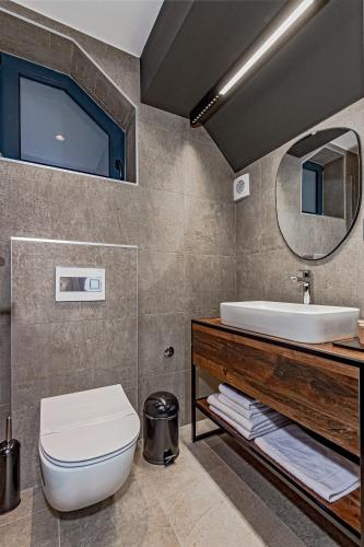 a bathroom with a sink and a toilet and a mirror at Hotel Ub Aqua Park in Ub