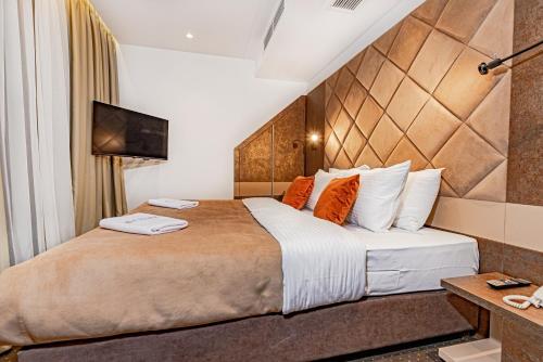 a hotel room with a large bed with orange pillows at Hotel Ub Aqua Park in Ub