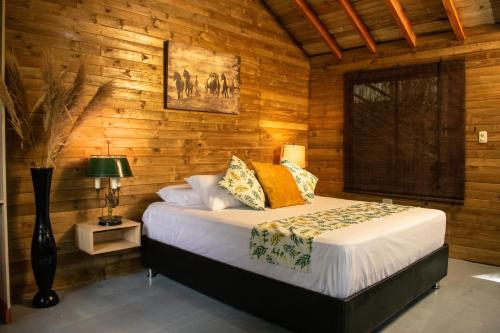 a bedroom with a bed in a wooden wall at Hotel Pony Club La Vecindad Tayrona - Zaino in Calabazo