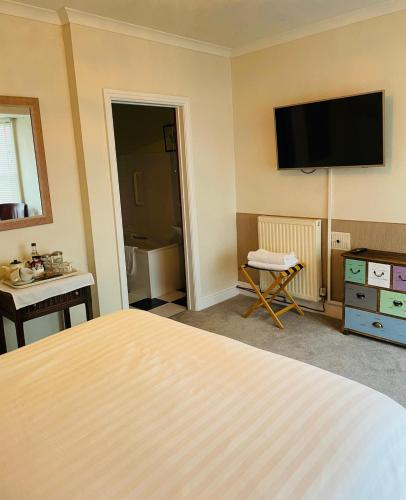a hotel room with a bed and a flat screen tv at Arosfa Harbourside Aberaeron in Aberaeron