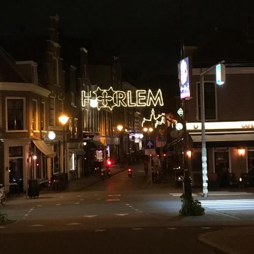 a city street at night with a lit up sign at De Haarlemse Logeerkamer in Haarlem