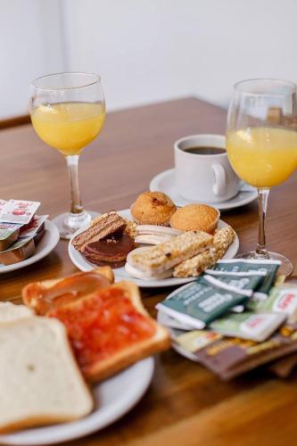 een tafel met borden eten en twee glazen sinaasappelsap bij Mar del Este in San Bernardo