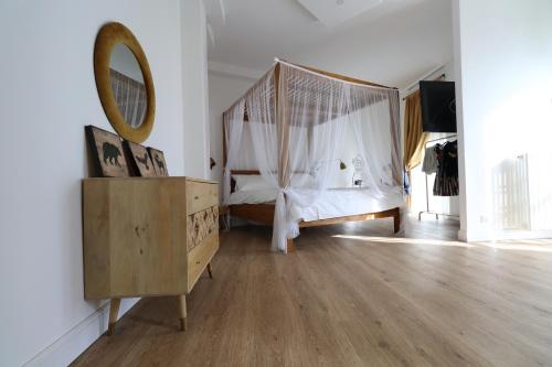 Baby Hotel في تورينو: غرفة نوم مع سرير مظلة ومرآة