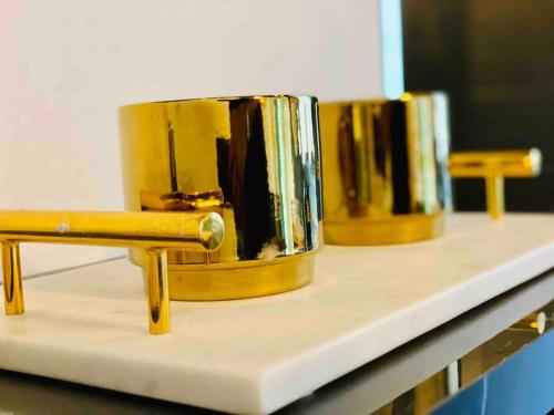 drie gouden trommels op een toonbank in een kamer bij Pasavento - Modern Black Suite in Camaceyes