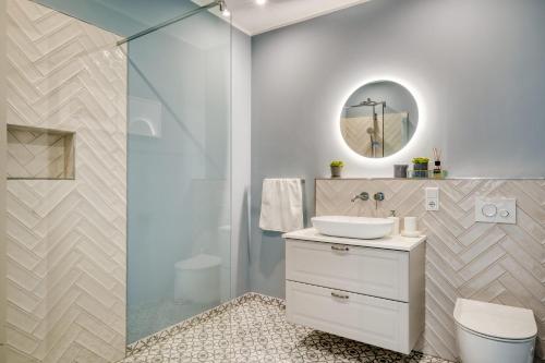 a bathroom with a white sink and a shower at One Moment Boardinghouse - Apartment Harmony in Porta Westfalica