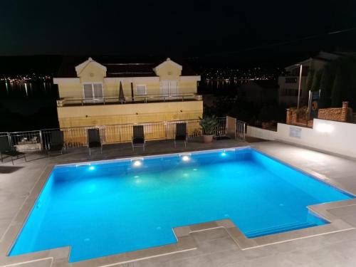 a swimming pool at night with a house in the background at Villa Luna in Trogir