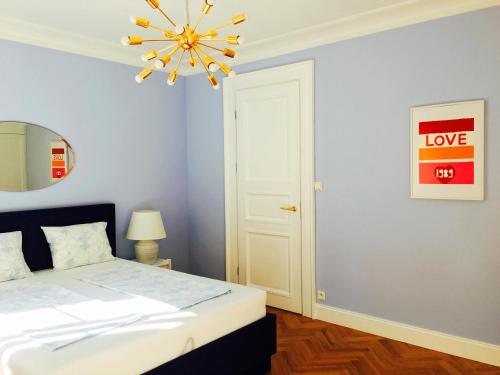 a bedroom with a bed and a chandelier at Rycerska - Stone Steps Apartments in Warsaw