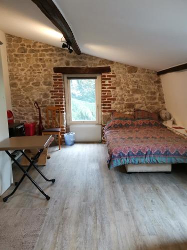 une chambre avec un lit et un mur de briques dans l'établissement Studette de jeanne, à Orléans