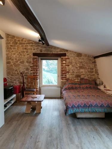 une chambre avec un lit et un mur de briques dans l'établissement Studette de jeanne, à Orléans
