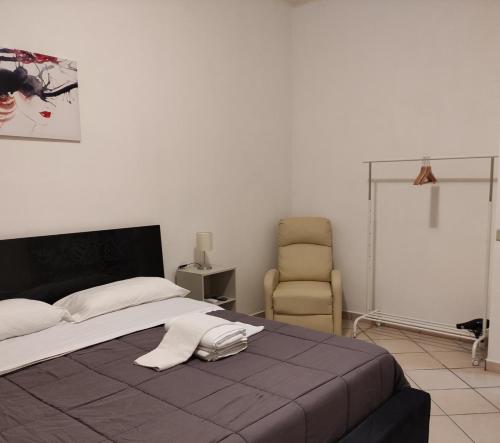 1 dormitorio con 1 cama y 1 silla en Lorenzo B&B House en Battipaglia