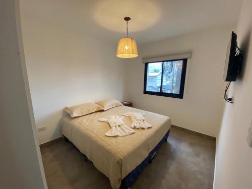 sypialnia z łóżkiem z dwoma ręcznikami w obiekcie La Escondida Salta 6 w mieście General Alvarado