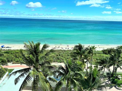 a view of a beach with palm trees and the ocean at Ocean Front Units at Miami Beach in Miami Beach