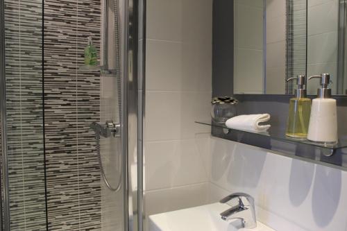 a bathroom with a shower and a sink and a mirror at The Hill B&B in Middleton in Teesdale