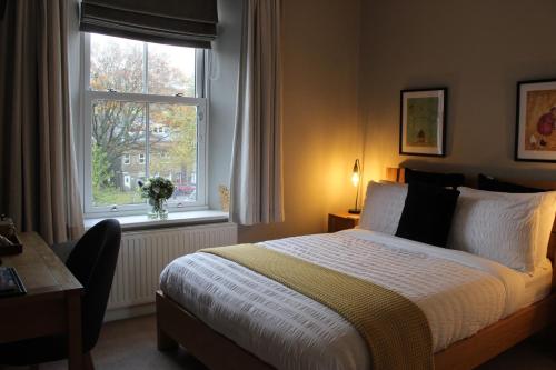a bedroom with a bed and a window and a desk at The Hill B&B in Middleton in Teesdale