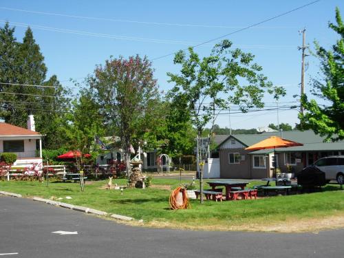 a park with tables and umbrellas on the side of the road at Jumping Frog Motel in Angels Camp