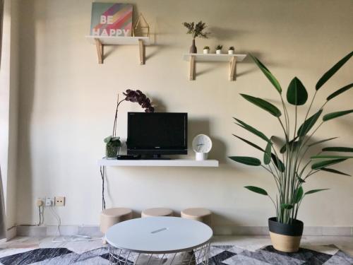 ein Wohnzimmer mit einem Tisch und einer Pflanze in der Unterkunft Port Dickson Glory Beach Resort Apartment 5pax 3BR in Port Dickson