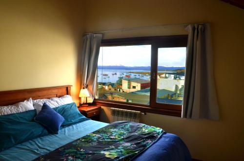- une chambre avec un lit et une grande fenêtre dans l'établissement Ushuhouse Apartments, à Ushuaia