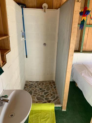 y baño con ducha y lavamanos. en Cabañas Casa Soley en Puerto Soley