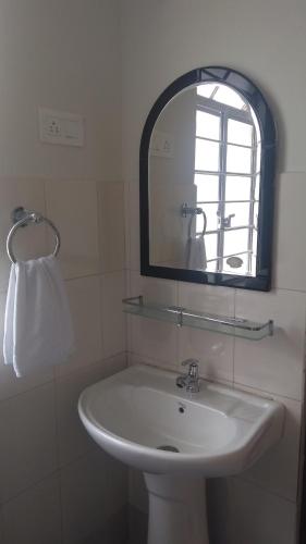 a bathroom with a sink and a mirror at Cassiopeia Guest House in Shillong