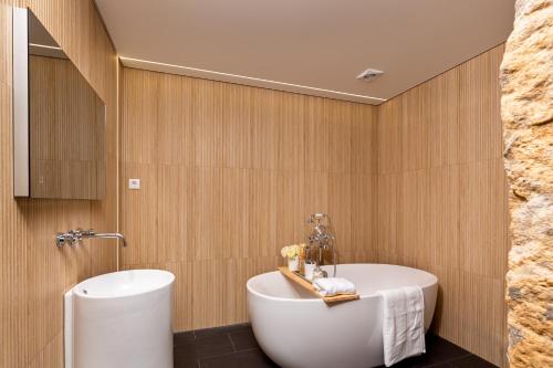 a bathroom with a white tub and a sink at Casas Casal de Nino in Celorico de Basto
