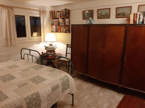 a bedroom with a bed and a large wooden cabinet at Masia del Viento in Mar del Sur