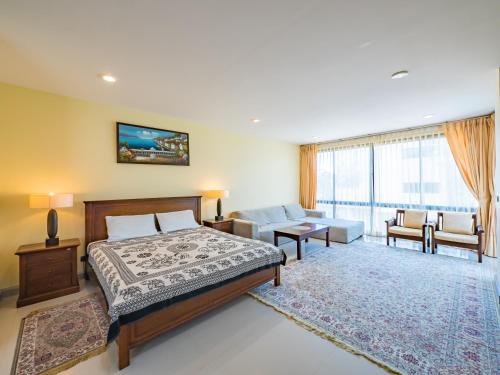 ein Schlafzimmer mit einem Bett und ein Wohnzimmer in der Unterkunft Condo AVANTA Deluxe A201 in Ban Tai