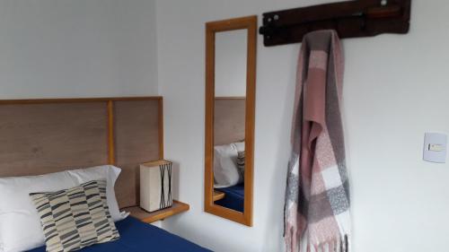 a bedroom with a mirror next to a bed at Casona Los Arri in Ushuaia