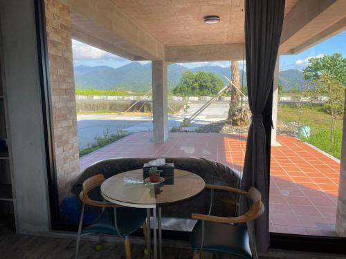 a room with a table and chairs and a large window at Bafentian Farmhouse in Guilin