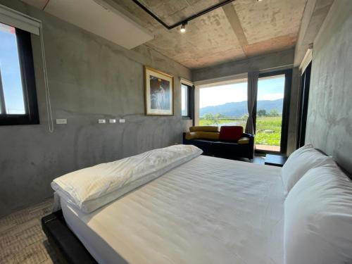 a bedroom with a bed and a couch and windows at Bafentian Farmhouse in Guilin