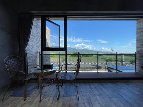 a room with a table and chairs and a large window at Bafentian Farmhouse in Guilin