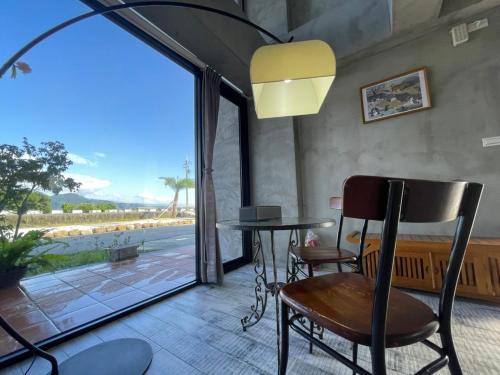 a room with a table and chairs and a large window at Bafentian Farmhouse in Guilin