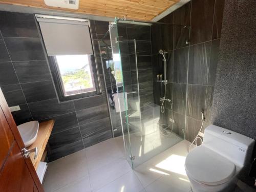 a bathroom with a toilet and a glass shower at Bafentian Farmhouse in Guilin