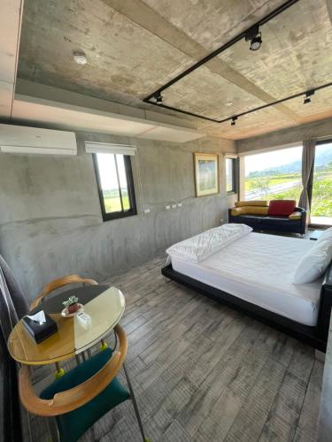 a bedroom with a bed and a table and chairs at Bafentian Farmhouse in Guilin