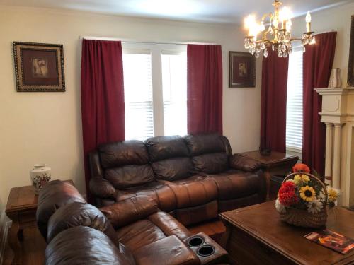 a living room with a leather couch and a table at Brick House Retreat in Hamlet
