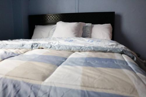 Una cama con una manta azul y blanca. en Tazama place, en Nyeri