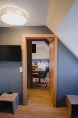 a room with a door leading into a room with a table at Hotel Restaurant DAS RÖSSL in Windischgarsten