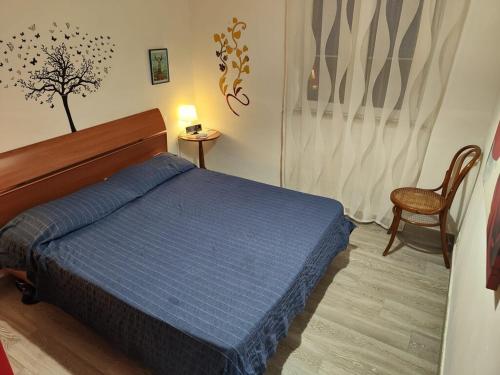 Un dormitorio con una cama azul y una silla. en Alcamo Marina Villa Pool, en Alcamo Marina