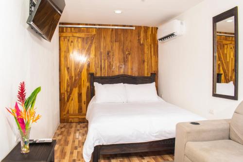 a bedroom with a bed with a wooden wall at Black Snapper House in Golfito