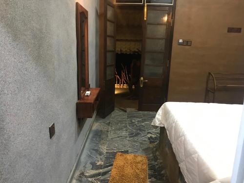 a bedroom with a bed and a hallway with a fireplace at Ceylon Resort in Wilpattu