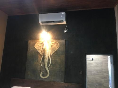 a light with an elephant on a wall at Ceylon Resort in Wilpattu