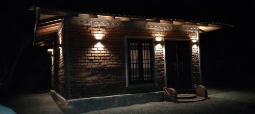 a brick building with lights on it at night at Ceylon Resort in Wilpattu